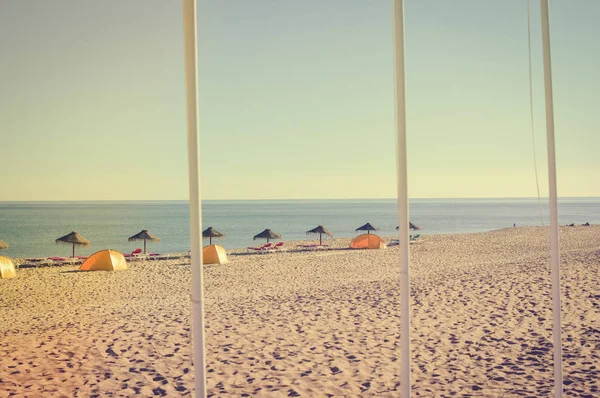 Niebieski niebo i plaży parasol krzesło na piękne tropikalne ocean wybrzeża, tło sceniczny słoneczny na zewnątrz — Zdjęcie stockowe