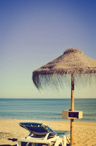 Parasole plażowe i kanapy na tle na zewnątrz niebieski niebo — Zdjęcie stockowe