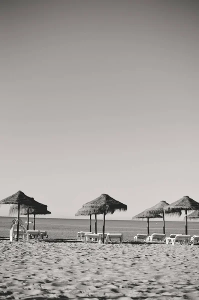 Ciel ensoleillé et chaises longues avec parasol sur la belle plage du Portugal — Photo