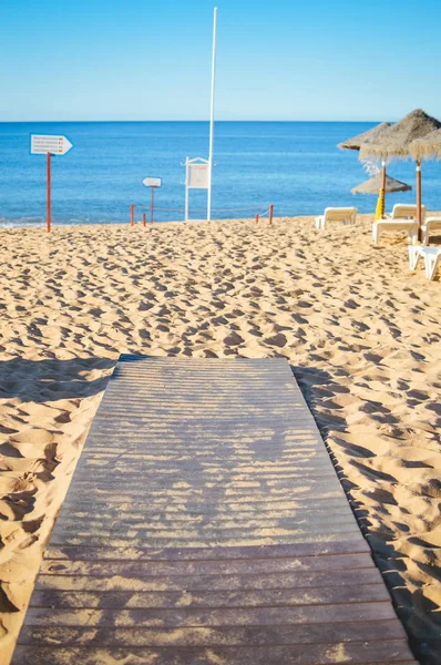 Sonniger Himmel und Liegestühle mit Sonnenschirm am schönen Strand von Portugal — Stockfoto