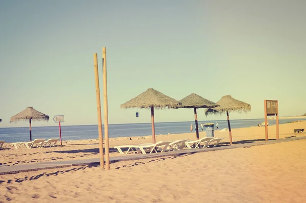 Cielo soleado y sillas con sombrilla en la hermosa playa de Portugal — Foto de Stock