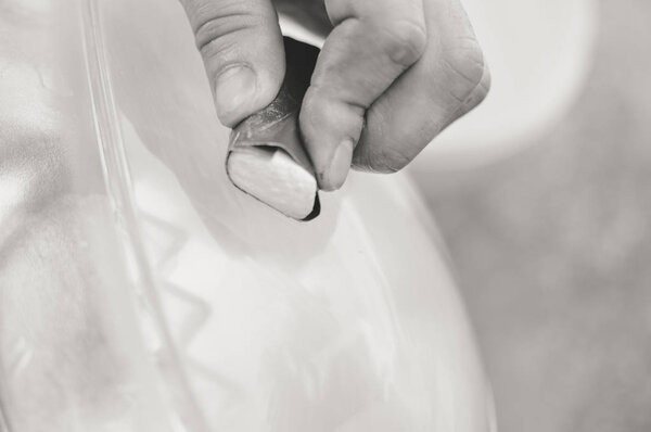 Автомобильная промышленность. Закройте глаза на автомобильную деталь - мужской лак для рук в авторемонтной мастерской. Профессиональное лицо при механическом обслуживании, ремонте промышленных деталей
