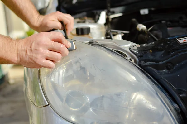 Industria automotriz. Primer plano en el detalle del coche - esmalte de mano masculino en el fondo del taller de reparación de automóviles. Persona profesional durante el mantenimiento mecánico, renovación del transporte de piezas industriales — Foto de Stock