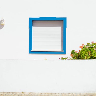 Dış duvarın arka planında metal kapaklı pencere.