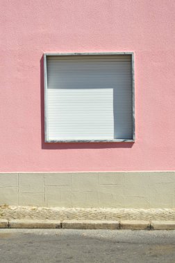 Dış duvarın arka planında metal kapaklı pencere.