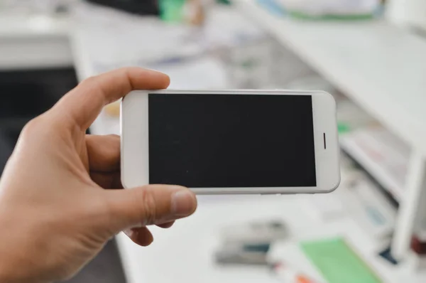 Бізнесмен використовує мобільний телефон на світлому фоні для фото або відео. Написання тексту, перевірка дзвінків, читання повідомлень. Крупним планом зображення пристрою комунікаційних технологій — стокове фото