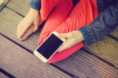 Closeup kumlu plaj arka plan üzerinde hareket eden smartphone kullanan kişi üzerinde. Çevrimiçi bağlantı, iletişim mesajlaşma, bankacılık için fotoğraf konsepti.