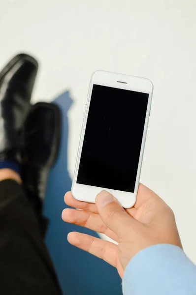 Business man hand holding using mobile smart phone on light background. Closeup view of mock up display network connection — Stock Photo, Image