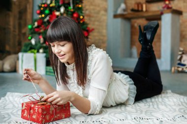 Genç kadın hediye kutusu paketini açmalısınız. Kavram yeni yıl, mutlu Noeller,