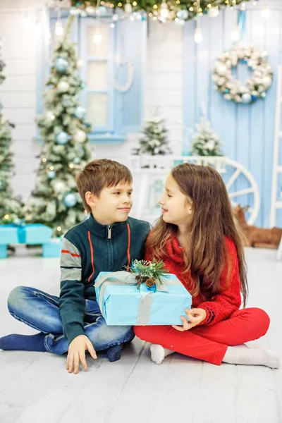 Hermano y hermana abren regalos. El chico y la chica. Concepto nuevo — Foto de Stock