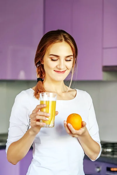Fiatal lány iszik narancslé. A nő van egy narancssárga. Br — Stock Fotó