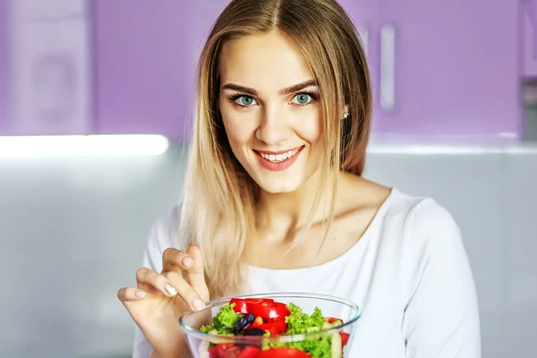 Fiatal, boldog lány étkezési növényi tavaszi saláta. — Stock Fotó