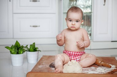 Küçük bebek, mutfakta oturuyor. Kız. 