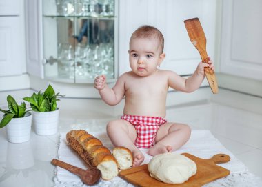 Küçük bebek mutfakta oturmuş.