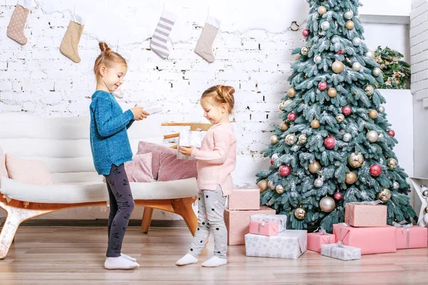 Dos niños pequeños miran los regalos. Concepto Año Nuevo, Feliz Cristo — Foto de Stock