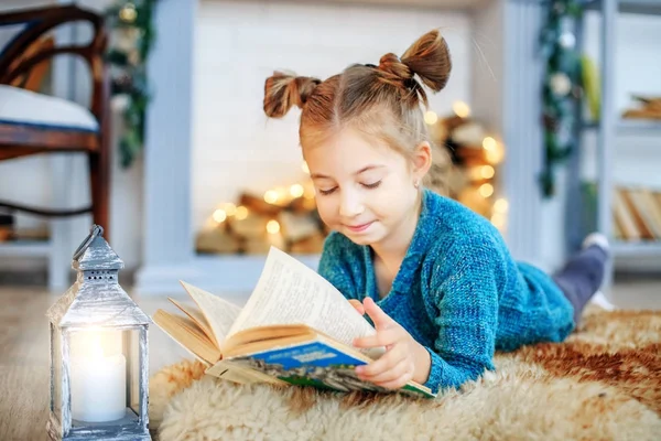A little child reads a book in the room. Concept New Year — Stock Photo, Image