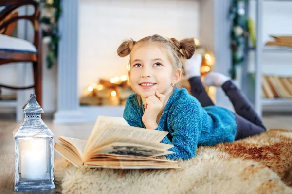 A little beautiful child reads a fairy tale in a book. — Stock Photo, Image