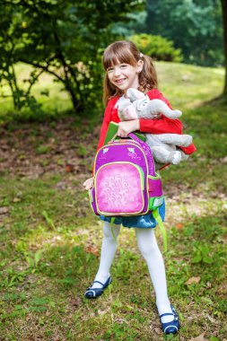 Küçük öğrenci okul bir sırt çantası ile bırakır.. 