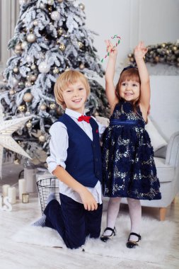 Kardeşi ve kız kardeşi Noel ağacı yakınındaki bir odada.
