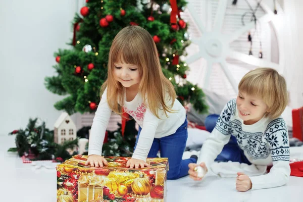 작은 오 빠와 여동생 선물을 풀으십시오. 크리스마스의 개념 — 스톡 사진