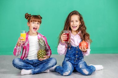 İki çocuk suyu içmek ve sevinirler. Ananas kızlarla 