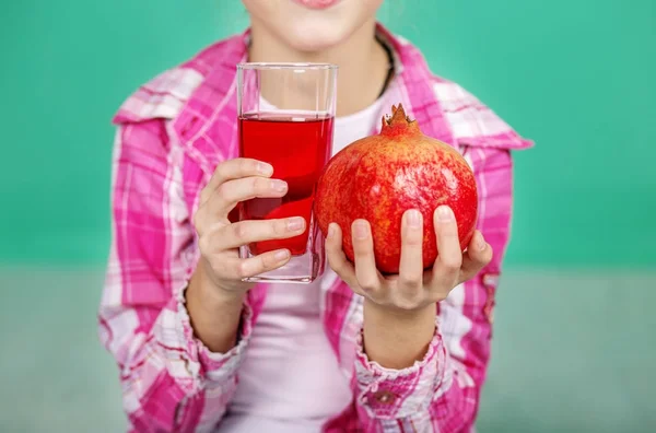 Ein Kind mit nützlichem Saft und Granatapfel. — Stockfoto