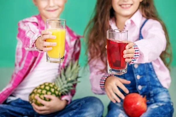 Kinder mit Fruchtsaft und Ananas und Granatapfel. — Stockfoto