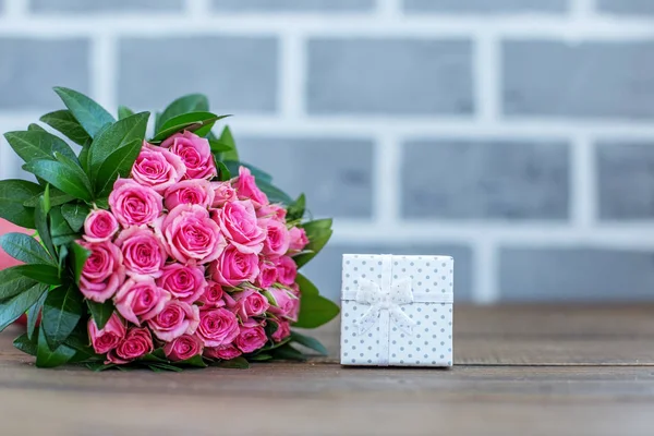 Gift and bouquet of roses. Place for the inscription. Concept lo — Stock Photo, Image