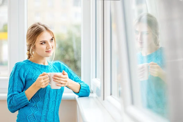 若い女の子は、茶を飲むし、窓の外に見える. — ストック写真