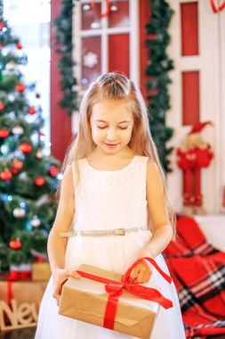 Küçük bir kız bir hediye kutusu açılır. Kavram yeni yıl, mutlu Noeller