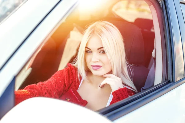 若いブロンドの女の子は、車をガイドします。日光。概念旅行 — ストック写真