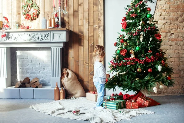 Hijita decora el árbol de Navidad . — Foto de Stock