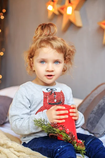 ベッドの上に座って美しい子。メリー クリスマスの概念 — ストック写真