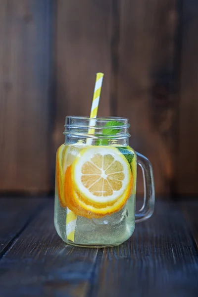 Portakal, limon ve nane ile su detoks. Ahşap arka plan. 