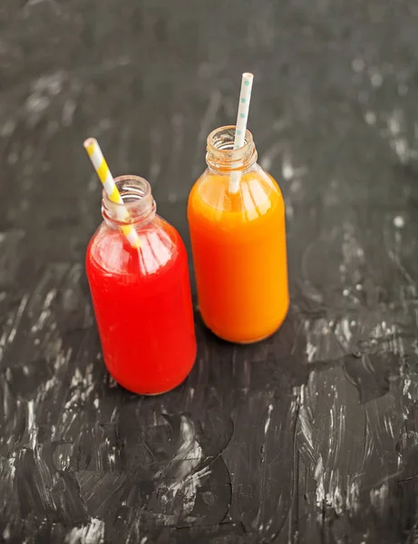 Sumo de morango e laranja. A garrafa de vidro . — Fotografia de Stock