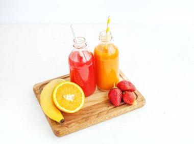 Meyve suyu şişelerde. Muz, portakal ve çilek.