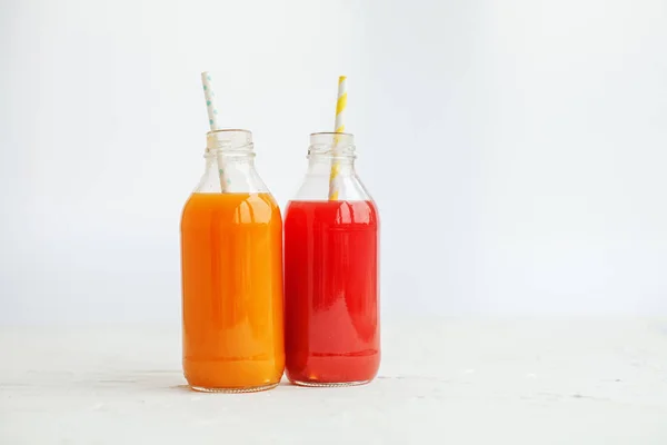 Strawberry and peach juice. The glass bottle. White background. — Stock Photo, Image