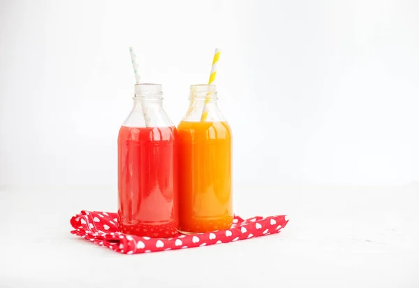 Grapefruit and peach juice. The glass bottle. White background. — Stock Photo, Image