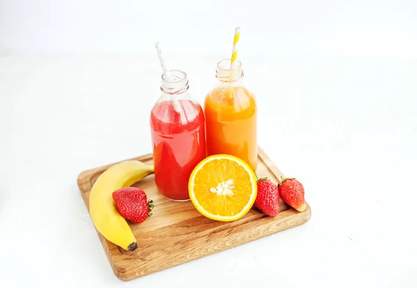 Suco em garrafas. Banana, laranja e morangos. Vista superior . — Fotografia de Stock