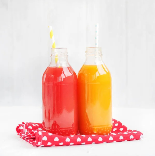 Strawberry and peach juice. The glass bottle. White background. — Stock Photo, Image