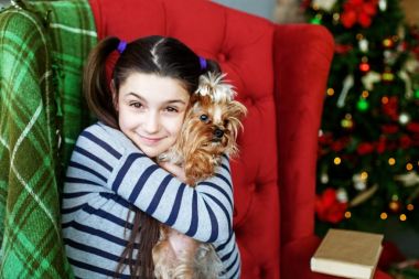 Bir çocuk köpeğini sarılmak. Kız öğrenci. Noel kavramı 