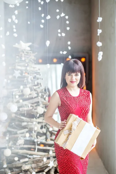 Bir hediye kutusu ile mutlu bir kadın. Kırmızı elbiseli kız. 