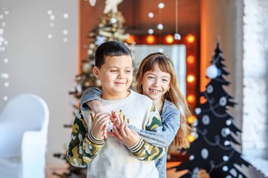 Çocuk sarılmak ve gülmek. Kız ve erkek kardeşim odada.