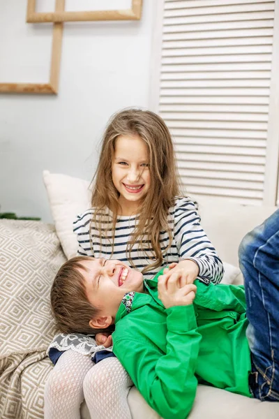 Two children rampant on the couch. The boy and the girl. — Stock Photo, Image