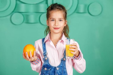 Kahvaltıda portakal suyu çocuk kız içecekler. 