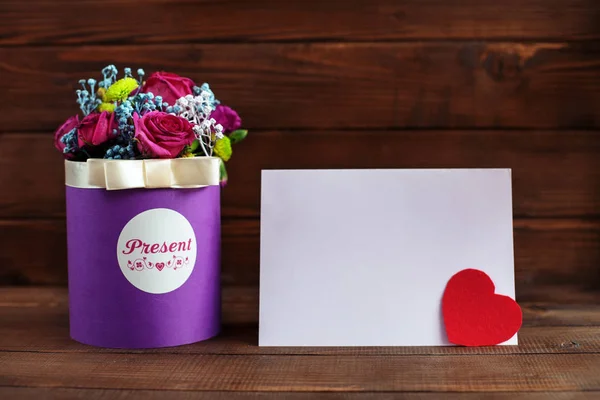 Красиві фіолетові квіти в коробці на дерев'яному фоні . — стокове фото