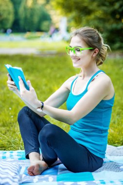 Zeki öğrenci parkta ilginç bir kitap okuma.