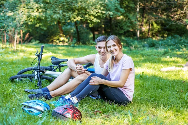 Są młodzi ludzie szczęśliwy w miłości. Spaceru w parku na rowery. — Zdjęcie stockowe