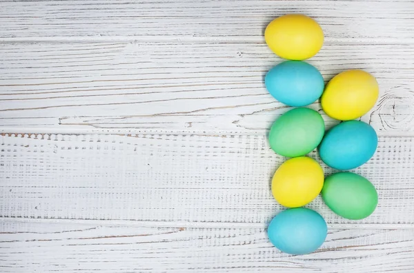 Oeufs colorés sur un fond en bois blanc. Concept Joyeux Pâques . — Photo