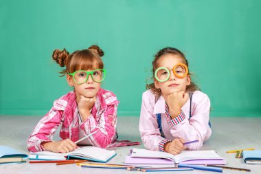 İki küçük kız bardaklarda ödev öğretilir.